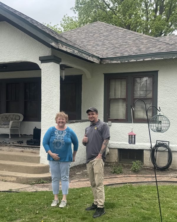 A homeowner and one of our crew giving a thumbs up in front of her finished house