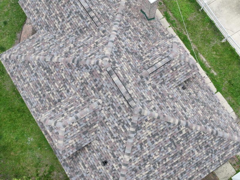 An aging but intact asphalt shingle roof seen from the drone, the kind rejuvenation is for